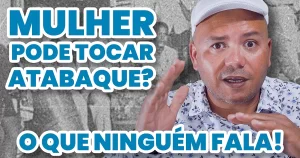 Imagem do Ogã Leandro usando chapéu branco e camisa estampada, gesticulando enquanto fala, ao lado da frase "Mulher pode tocar atabaque? O que ninguém fala!" em letras azuis. Fundo em preto e branco com figuras históricas. Imagem de capa do artigo Mulheres Tocando Atabaques no Candomblé: Uma Reflexão Necessária.
