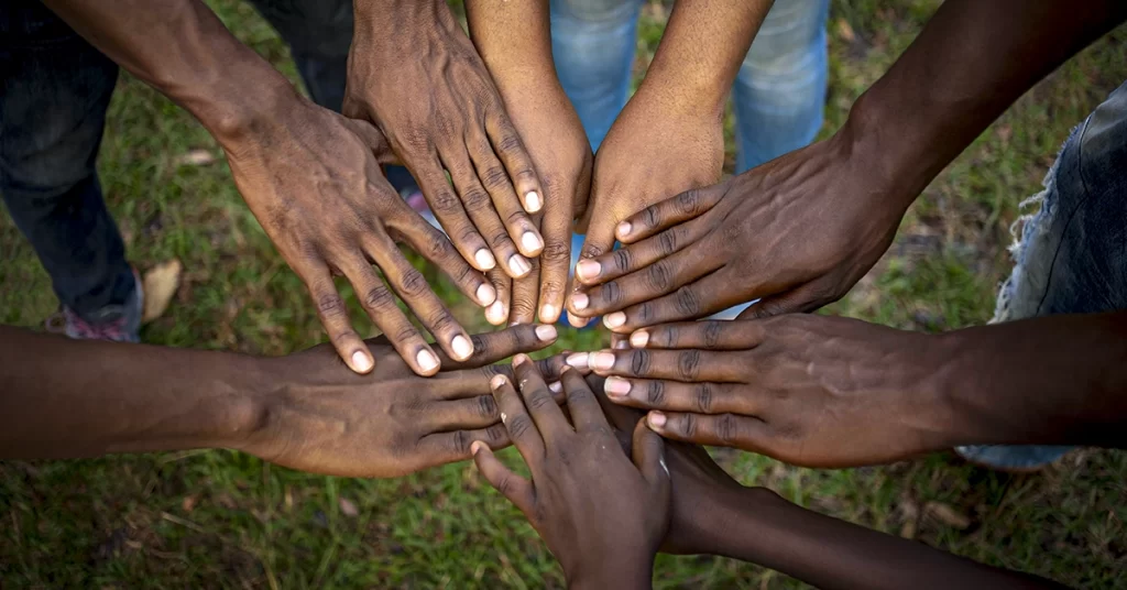 Mãos unidas em círculo representando diversidade e união.