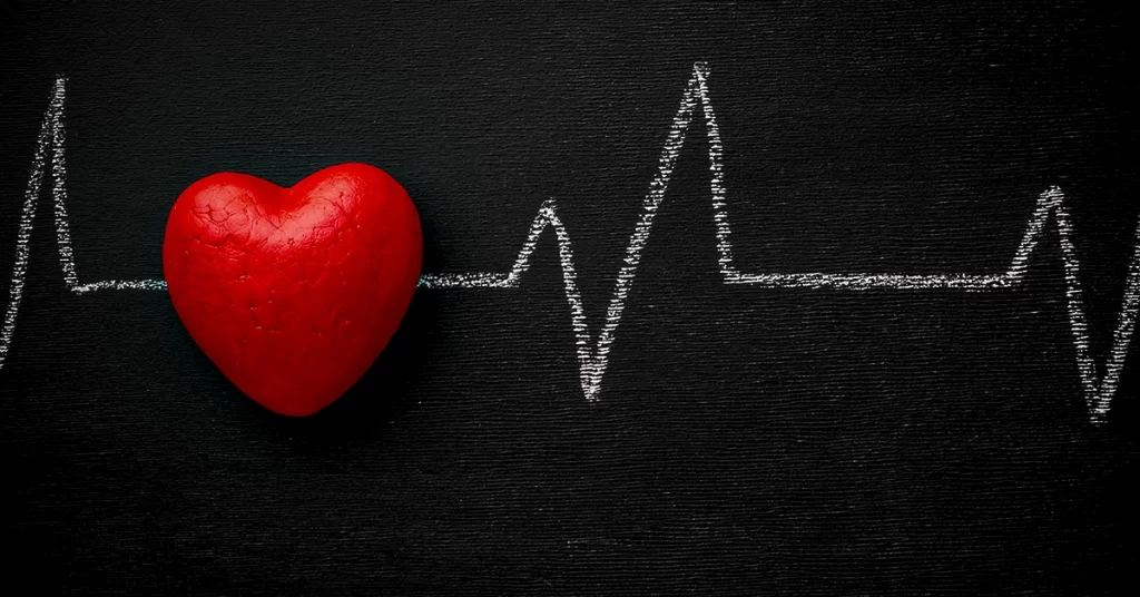 Eletrocardiograma desenhado no quadro-negro com coração vermelho
